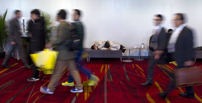 An attendee at CES takes a nap outside of a showroom within the Las Vegas Convention Center on Wednesday, Jan. 8, 2014.