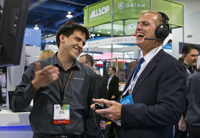 (from left) Matt Payne shows Don Houston of Plantronics some of the great new technology they have produced in their display at CES within the Las Vegas Convention Center on Wednesday, Jan. 8, 2014.