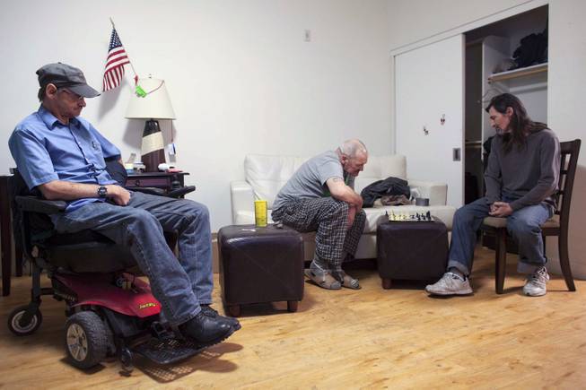 John Hankins, right, who repaired ballistic missiles for the Air Force, plays chess with William Godwin as Gary Workman, left, watches, in Phoenix, Jan. 8, 2014. All three veterans were considered chronically homeless but now live in Victory Place, apartments subsidized by the city government in Phoenix, which believes there are no more former servicemen living on its streets.