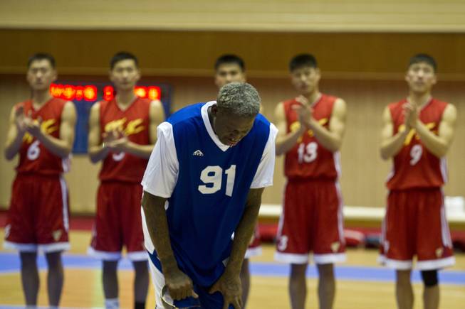 Dennis Rodman bows to North Korean leader Kim Jong Un, seated above in the stands, after singing Happy Birthday to Kim before an exhibition basketball game with U.S. and North Korean players at an indoor stadium in Pyongyang, North Korea on Wednesday, Jan. 8, 2014.