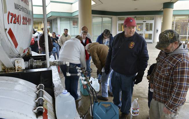 David Fletcher, center, a member of the Belle Fire Department, took off a day of work at his accounting job for the state so he could help distribute water at Riverside High School in Charleston, W.Va., after a chemical spill in the Elk River in Charleston shut down much of the city and surrounding counties, Friday Jan 10, 2014.  He said that earlier he dropped off some water for some of his elderly neighbors.