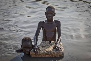 Young displaced boys bathe in a reservoir inside one of the camps for people who have fled the recent violence, in the capital Juba, South Sudan Saturday, Jan. 11, 2014.