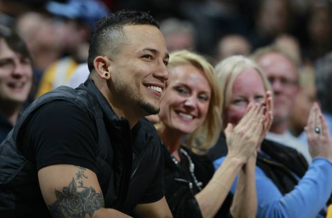 Colorado Rockies outfielder Carlos Gonzalez smiles as the crowd applauds as he is introduced in the fourth quarter while sitting courtside to watch the Miami Heat's 97-94 victory over the Denver Nuggets in an NBA basketball game in Denver on Monday, Dec. 30, 2013.