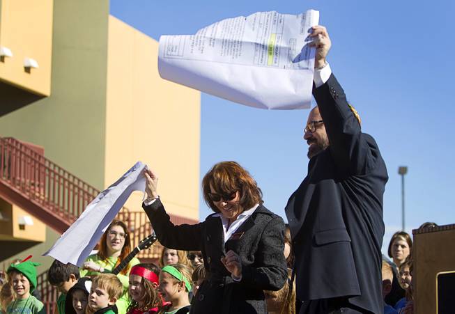 Jacky Rosen, left, congregation president, and Rabbi Sanford Akselrad tear up an oversized NV Energy bill during a news conference to "unveil" a solar photovoltaic field at Temple Ner Tamid in Henderson Sunday, Jan. 12, 2014. 