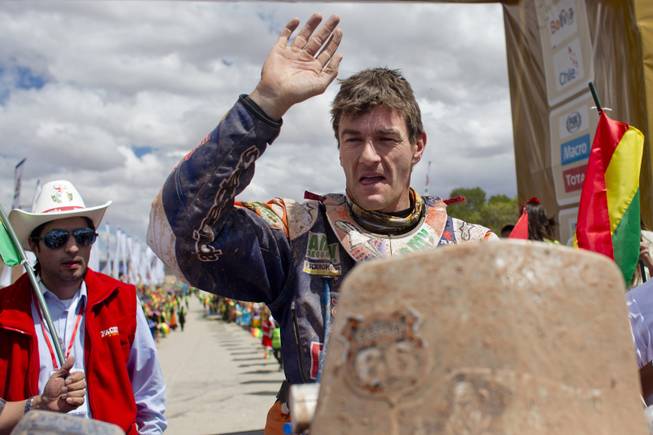 KTM rider Marc Coma of Spain waves as he arrives at the end of the seventh stage of the Dakar Rally in Uyuni, Bolivia, Sunday, Jan. 12, 2014. 