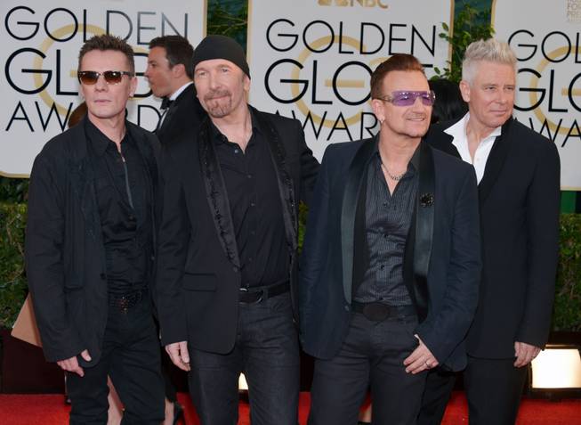 From left, Larry Mullen, Jr., The Edge, Bono and Adam Clayton, of the musical group U2, arrive at the 71st annual Golden Globe Awards at the Beverly Hilton Hotel on Sunday, Jan. 12, 2014, in Beverly Hills, Calif. 