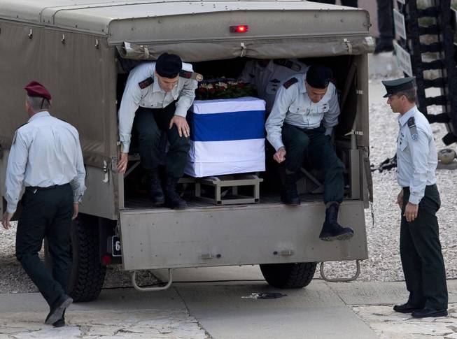 Israeli generals jump off a military vehicle with the coffin of former Israeli Prime Minister Ariel Sharon as it stops at the Armored Corps memorial for fallen soldiers in Latrun, site of a bloody battle where Sharon was wounded during Israel's war of independence in 1948, for a brief ceremony before continuing south,  near Jerusalem, Israel, Monday, Jan. 13, 2014. 