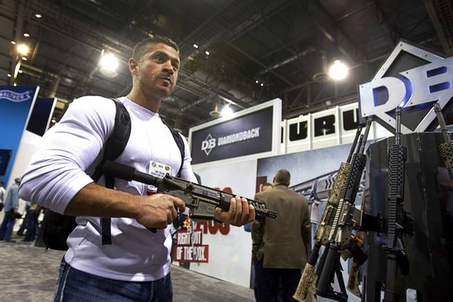 Tony Toscano, manager of Nevada Guns and Gear in Henderson, poses with a semiautomatic rifle at the Diamondback Firearms booth during the 2014 SHOT Show (Shooting, Hunting, Outdoor Trade) at the Sands Expo & Convention Center Tuesday, Jan. 14, 2014. The show features more than 1,600 exhibitors covering 630,000 square feet and attracts more than 62,000 attendees.