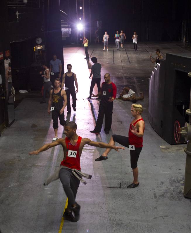 Male dancers warm up in the wings as others run through a choreographed piece during "Jubilee!" auditions on Tuesday, Jan. 14, 2014.