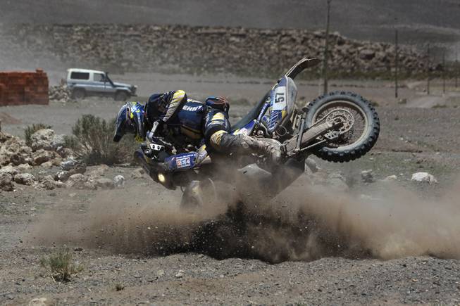 Yamaha rider Bruno Da Costa of France falls from his bike during the eighth stage of the Dakar Rally between the cities Uyuni, Bolivia and Calama, Chile in Kui, Bolivia, Monday, Jan. 13, 2014. 