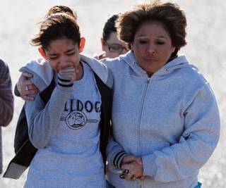 A student, left, is hugged after being united with families following a shooting at Berrendo Middle School, Tuesday, Jan.14, 2014, in Roswell, N.M.