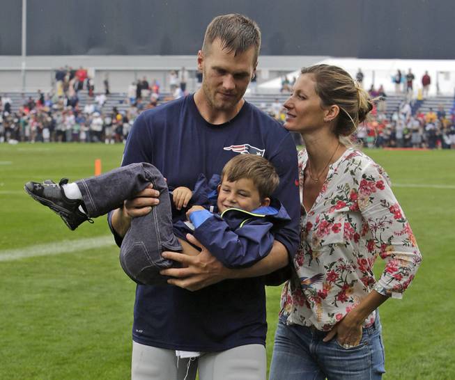New England Patriots quarterback Tom Brady and his wife, Gisele Bundchen, with their son, Benjamin Brady, after a joint workout with the Tampa Bay Buccaneers at NFL football training camp in Foxborough, Mass., Tuesday, Aug. 13, 2013. 