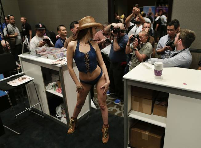 Porn start Riley Reid poses for industry photographers and fans during the Adult Entertainment Expo, Wednesday, Jan. 15, 2014, in Las Vegas. Potential opportunities for X-rated film production in Nevada were the talk of the Expo at the Hard Rock hotel and casino this week, sparked by a Los Angeles law requiring male actors to wear condoms.