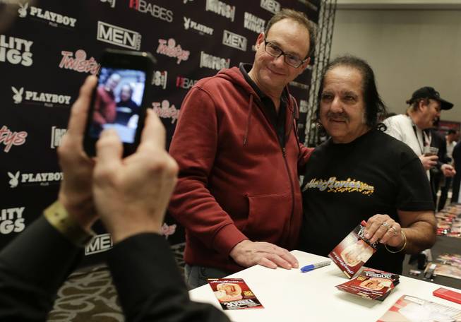 Porn star Ron Jeremy poses for a photo with a fan while signing autographs during the Adult Entertainment Expo, Wednesday, Jan. 15, 2014, in Las Vegas. Potential opportunities for X-rated film production in Nevada were the talk of the Expo at the Hard Rock hotel and casino this week, sparked by a Los Angeles law requiring male actors to wear condoms.