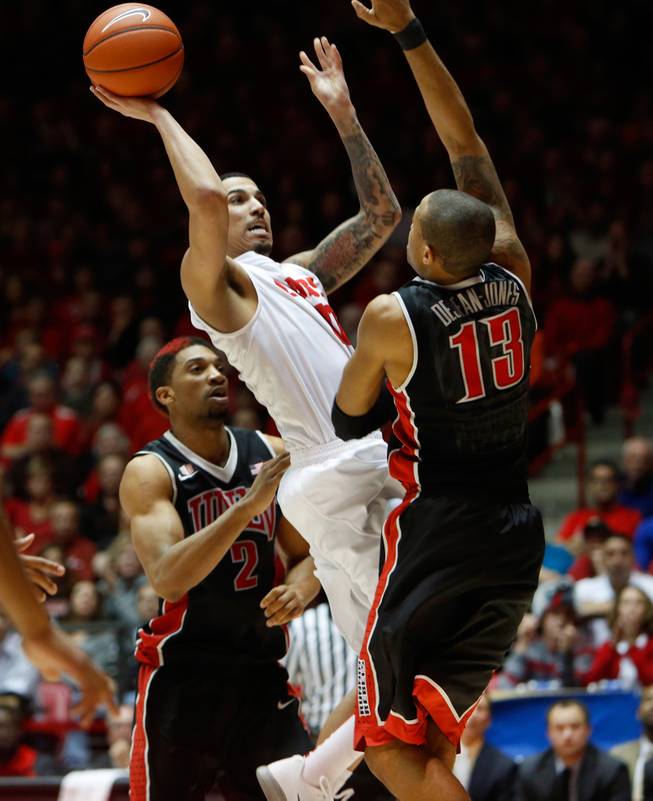 New Mexico's Kendall Williams shoots over UNLV's Bryce Dejean Jones, right, and Khem Birch in the second half of an NCAA college basketball game Wednesday, Jan. 15, 2014 in Albuquerque, N.M. UNLV won 76-73.