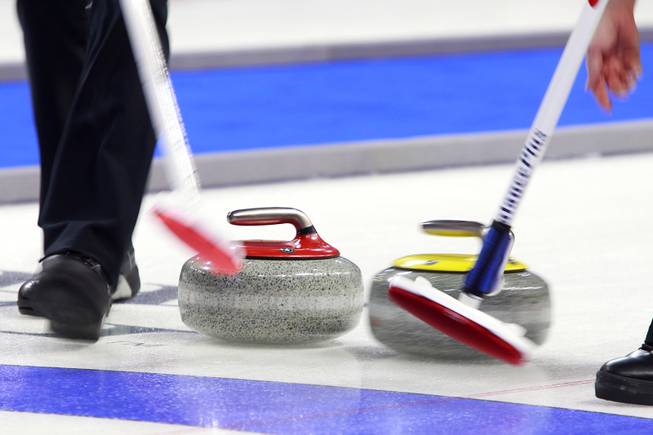 Sweepers try to position their stone during the first day of the 2014 World Financial Group Continental Cup of Curling at the Orleans Arena Thursday, Jan. 16, 2014. Of the twelve teams competing from around the world, nine of them will represent their respective country at the upcoming Olympics in Sochi, Russia.