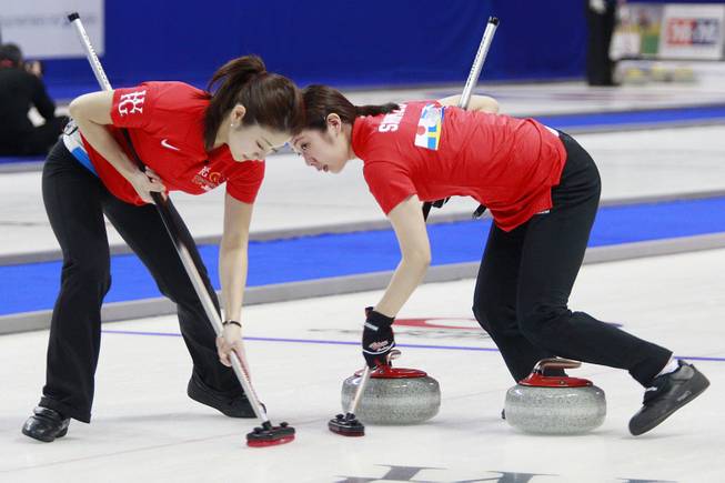 Miyo Ichikawa, left, and Emi Shimizu sweep in front of their stone during the first day of the 2014 World Financial Group Continental Cup of Curling at the Orleans Arena Thursday, Jan. 16, 2014. Of the twelve teams competing from around the world, nine of them will represent their respective country at the upcoming Olympics in Sochi, Russia.