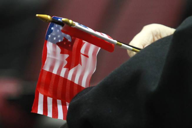 A fan holds a U.S. and Canadian flag during the first day of the 2014 World Financial Group Continental Cup of Curling at the Orleans Arena Thursday, Jan. 16, 2014. Of the twelve teams competing from around the world, nine of them will represent their respective country at the upcoming Olympics in Sochi, Russia.