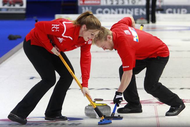 Christina Bertrup and Niklas Edin sweep during the first day of the 2014 World Financial Group Continental Cup of Curling at the Orleans Arena Thursday, Jan. 16, 2014. Of the twelve teams competing from around the world, nine of them will represent their respective country at the upcoming Olympics in Sochi, Russia.
