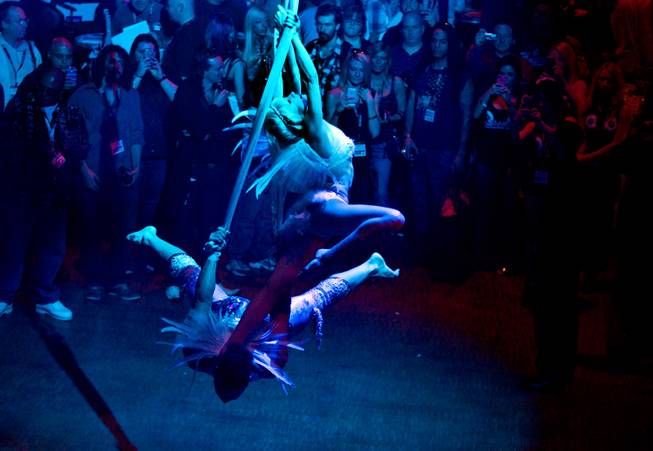 Aerial artists are bathed in blue light while entertaining the crowd at the AVN Adult Entertainment Expo on Thursday, Jan. 16, 2014.