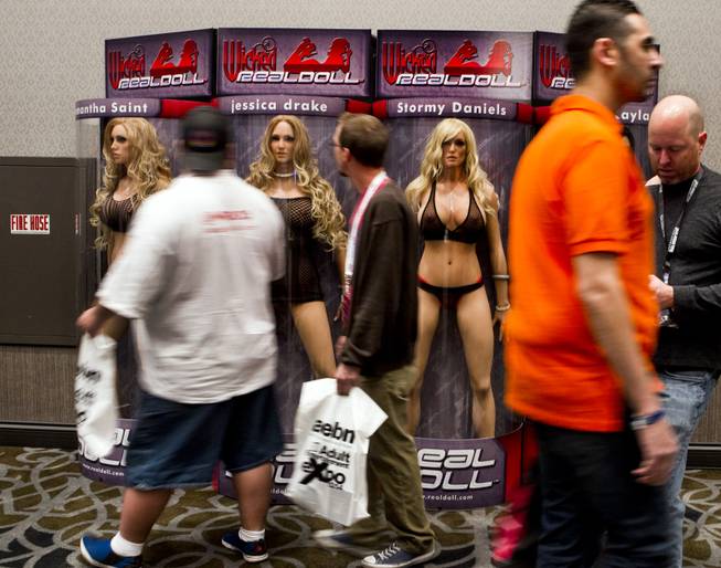 Attendees walk past life-size dolls of porn stars during the 2014 AVN and Adult Entertainment Expo in the Hard Rock Hotel on Thursday, Jan. 16, 2014.
