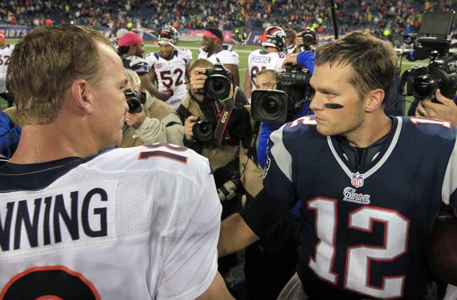 In this Oct. 7, 2012, file photo, Denver Broncos quarterback Peyton Manning, left, and New England Patriots quarterback Tom Brady, right, speak in the middle of the field after the Patriots beat the Broncos 31-21 in an NFL football game in Foxborough, Mass. 