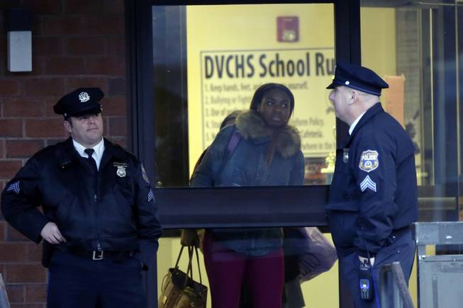 Studenta leave the Delaware Valley Charter School Friday, Jan. 17, 2014, in Philadelphia. Police say two students have been shot at a Philadelphia high school.