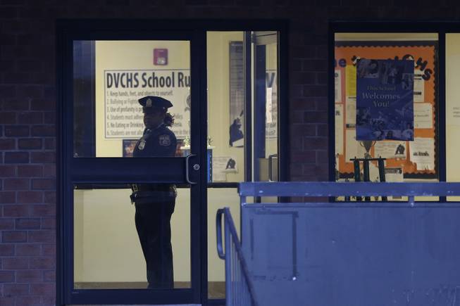 Police stands guard the Delaware Valley Charter School Friday, Jan. 17, 2014, in Philadelphia, after two students were shot by another student.