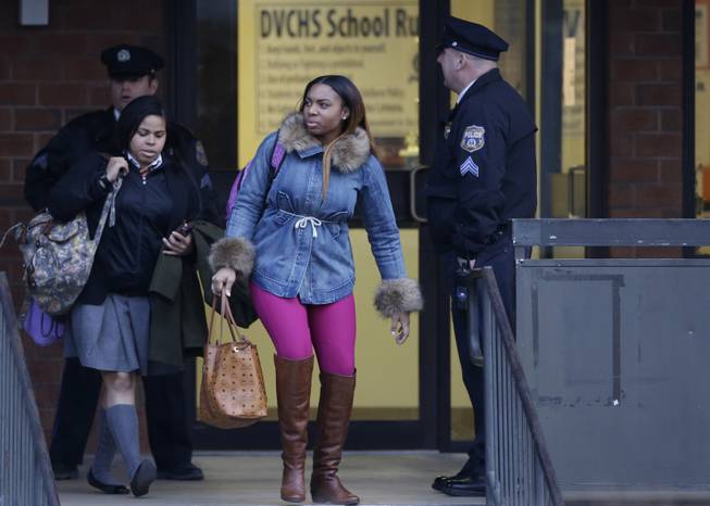 Students exit the Delaware Valley Charter School Friday, Jan. 17, 2014, in Philadelphia. Police say two students have been shot at a Philadelphia high school.