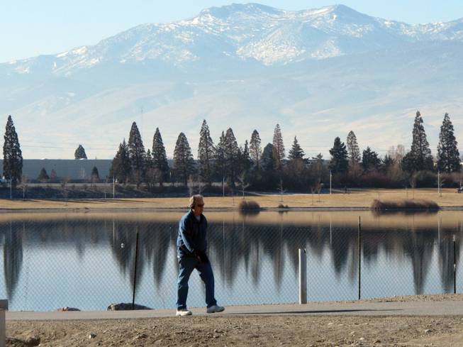 An unidentified man walks on the 2-mile loop trail surrounding the Sparks Marina, where all of the fish have died over the past month, on Friday, Jan. 17, 2014, in Sparks, Nev. 