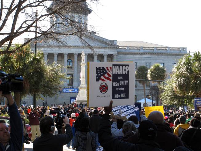 Marchers make their way to the South Carolina Statehouse during the King Day rally on Monday, Jan. 20, 2014, in Columbia, S.C. NAACP President William Barber told the crowd of a few thousand people that what conservatives leaders have done to the country is mighty low, but he thinks they are ready to find higher ground. 