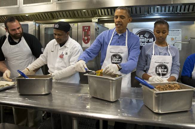 President Barack Obama and his daughter Sasha, right, make burritos at DC Central Kitchen as part of a service project in honor of Martin Luther King, Jr. Day,  Monday, Jan. 20, 2014, in Washington. Also helping were first lady Michelle Obama and daughter Malia Obama. 