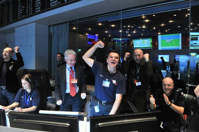 In this photo provided by the European Space Agency on Monday Jan. 20, 2014, technicians celebrate after receiving the Rosetta wake-up signal in the control room of ESA in Darmstadt, Germany.