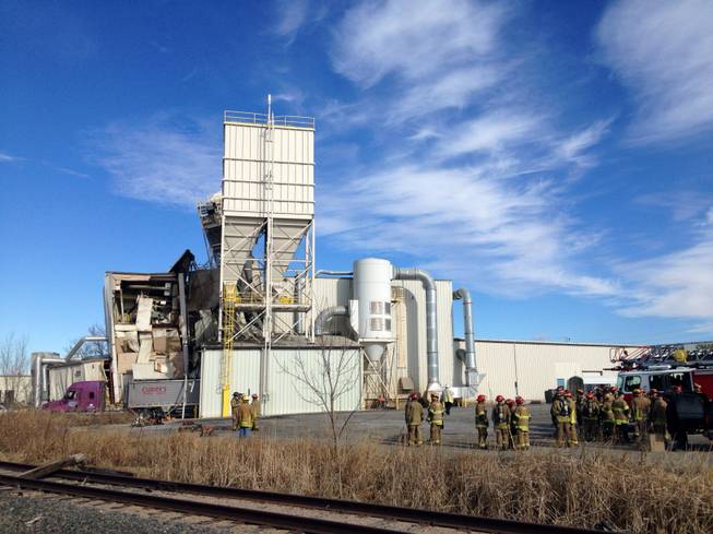 Firefighters stand outside the International Nutrition plant in Omaha, Neb., Monday, where a fire and explosion took place Jan. 20, 2014. At least nine people have been hospitalized and others could be trapped at the animal feed processing plant.