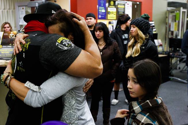 Telmo Torres, left, hugs RiRi Whiting, both friends of Kelly Boren, during a memorial service and candlelight vigil for the Boren family at the Gold's Gym in Spanish Fork, Utah, on Saturday, Jan. 18, 2014. Authorities believe Joshua Boren, a police officer, shot and killed his wife, mother-in-law and two young children before turning the gun on himself.