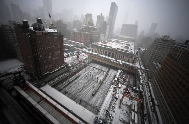 Early snowfall blankets ongoing construction of a platform for a twin tower hi-rise project, covering the Penn Station rail tracks on Tuesday, Jan. 21, 2014, in New York. Weather forecast calls for snow through mid-afternoon with temperatures steady in the low 20s.