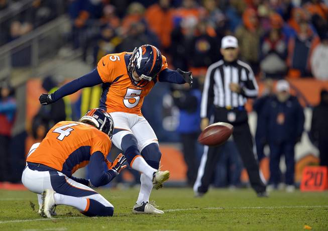 In this Jan. 12, 2014, photo, Denver Broncos kicker Matt Prater (5) kicks an extra point as Broncos punter Britton Colquitt (4) holds during the fourth quarter of an AFC divisional playoff NFL game against the San Diego Chargers in Denver.