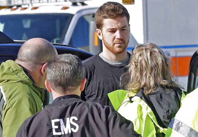 EMS personnel speak with an Cody Cousins, 23, who was detained after a shooting inside the Electrical Engineering building on the campus of Purdue University in West Lafayette, Ind. Cousins, of Warsaw, Ind., is being held in the Tippecanoe County Jail on a preliminary charge of murder, accused of shooting 21-year-old Andrew Boldt of West Bend, Wis. 