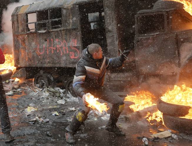 A protester throws a Molotov cocktail during clashes with police in central Kiev, Ukraine, Wednesday, Jan. 22, 2014. Three people have died in clashes between protesters and police in the Ukrainian capital Wednesday, according to medics on the site, in a development that will likely escalate Ukraine's two month-long political crisis. The mass protests in the capital of Kiev erupted after Ukrainian President Viktor Yanukovych spurned a pact with the European Union in favor of close ties with Russia, which offered him a $15 billion bailout.