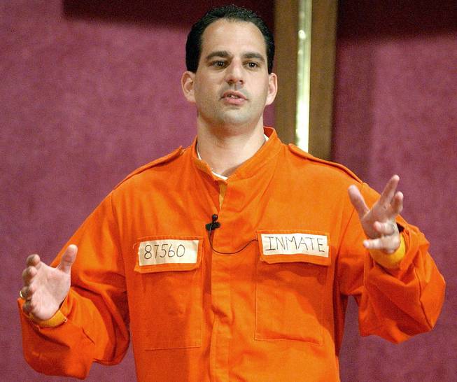 Barry Minkow, a convicted con artist and the co-founder of the for-profit Fraud Discovery Institute, wears a prison jumpsuit costume as he delivers a sermon on materialism at the Community Bible Church in San Diego, July 7, 2002.