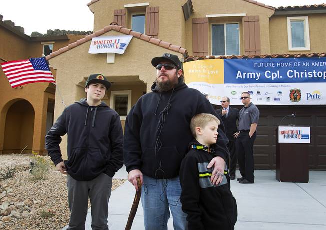 Army Sgt. Christopher Bales, center, and his sons Keenan, 14, and Aiden, 8, talk with reporters in front of their new home at the Coldwater Crossing subdivision in the Mountain's Edge master planned community Thursday Jan. 23, 2014. Pulte Homes, along with other companies, presented the home to Bales as part of Operation Finally Home," an organization which provides homes to veterans and the families of fallen servicemen.