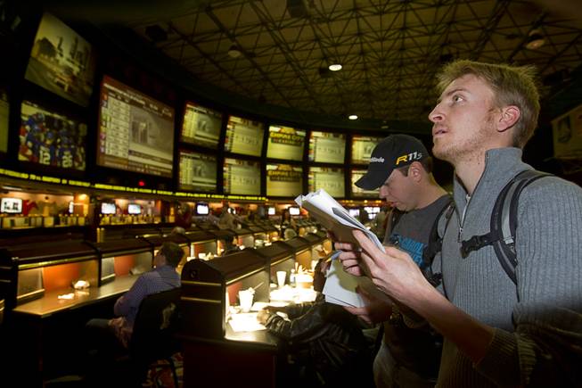Rufus Peabody, right, of Henderson looks over Super Bowl XLVIII proposition bets were posted on an electronic display board at the Las Vegas Hotel Superbook Thursday Jan. 23, 2014.
