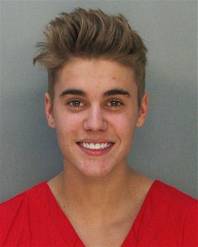 This police booking mug made available by the Miami Dade County Corrections Department shows pop star Justin Bieber, Thursday, Jan. 23, 2014. Bieber and R&B singer Khalil were arrested for allegedly drag-racing on a Miami Beach Street. Police say Bieber has been charged with resisting arrest without violence in addition to drag racing and DUI. Police also say the singer told authorities he had consumed alcohol, smoked marijuana and taken prescription drugs.