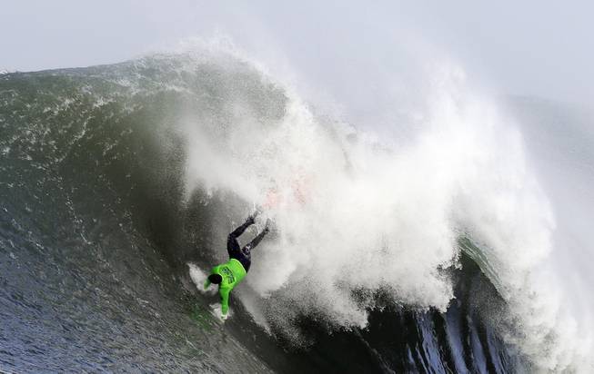 Ben Wilkinson goes tumbling into a wave during the third heat of the first round of the Mavericks Invitational big wave surf contest Friday, Jan. 24, 2014, in Half Moon Bay, Calif.