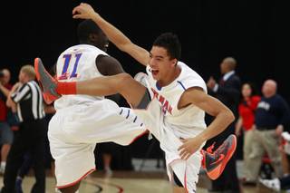 Bishop Gorman guards Obim Okeke, left, and Richie Thornton celebrate their 76-72 defeat of Findlay Prep in overtime Saturday, Jan. 25, 2014 at the South Point.