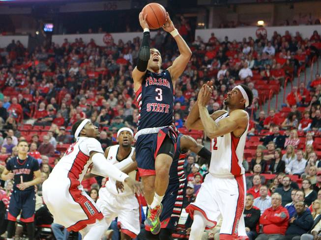 Fresno St. guard Cezar Guerrero finds an easy lane to the basket past UNLV guard Deville Smith, left, and forward Khem Birch during their game Saturday, Jan. 25, 2014 at the Thomas & Mack Center.