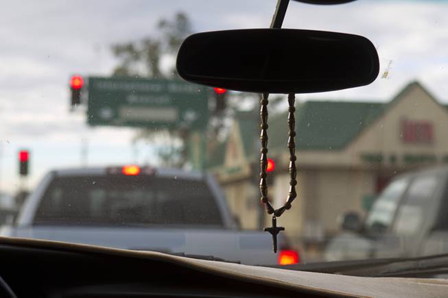 A crucifix hangs from the rear view mirror as the Diaz family prepares to cross the border into Mexicali, Mexico Saturday, Jan. 25, 2014.