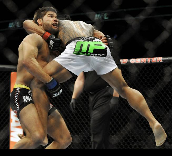 Josh Thomson, left, fights Benson Henderson during the main event of the UFC mixed martial arts event in Chicago, Saturday, Jan., 25, 2014. 