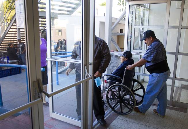 Assistant Jose Alberto Ramirez and Francisco Diaz of Las Vegas leave the general hospital after a doctor's appointment in Mexicali, Mexico Sunday, Jan. 26, 2014. Diaz was born in Mexico but grew up in Las Vegas with a green card. Diaz was beaten and robbed after he was deported to Mexicali.