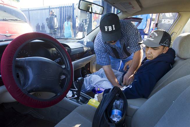 Assistant Jose Alberto Ramirez helps Francisco Diaz with a seatbelt as they leave the general hospital after a doctor's appointment in Mexicali, Mexico Sunday, Jan. 26, 2014. Diaz was born in Mexico but grew up in Las Vegas with a green card. Diaz was beaten and robbed after he was deported to Mexicali.